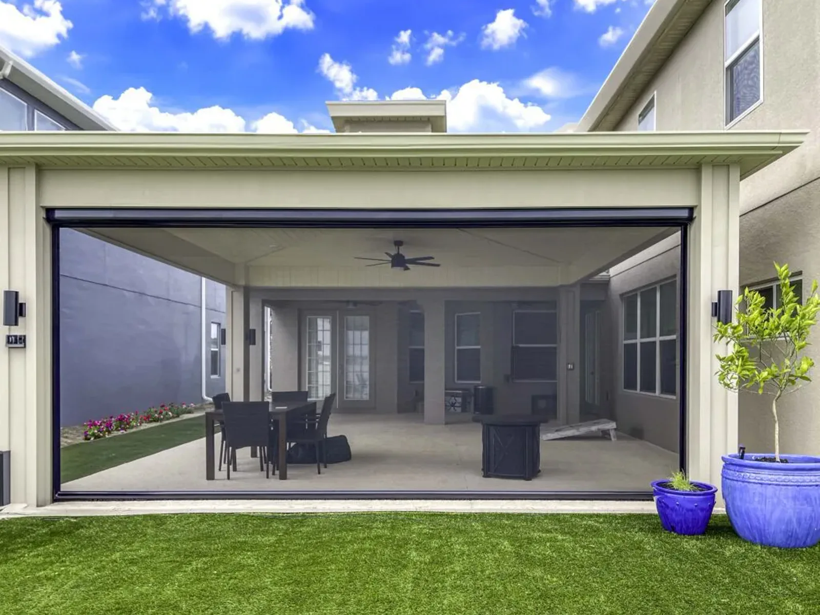 Houston patio framed by layered greenery and matching planters alongside a screened outdoor living area.