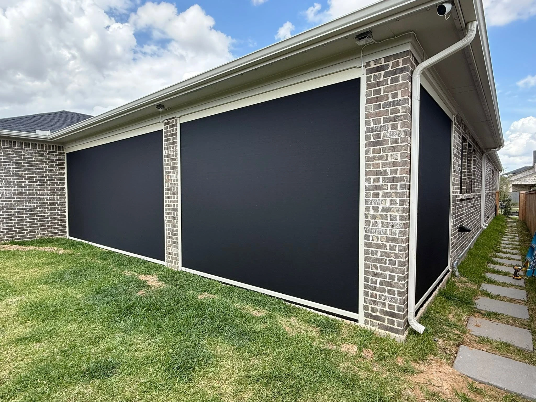 Motorized shade lowered over a Houston patio
