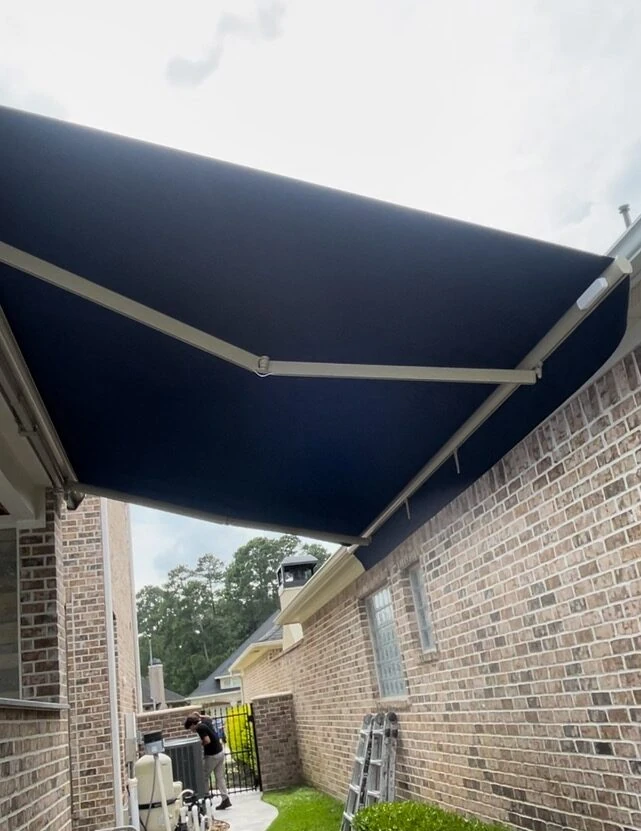 Motorized retractable awning shading a Houston outdoor living room