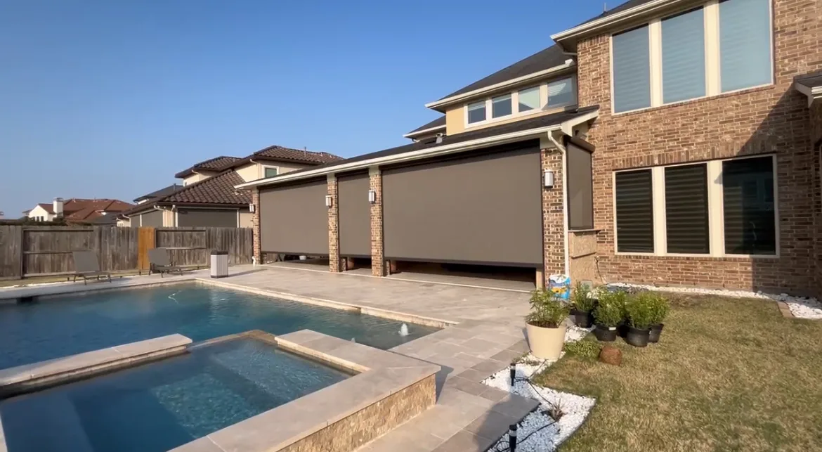 Motorized patio screen lowered over a Houston outdoor living room
